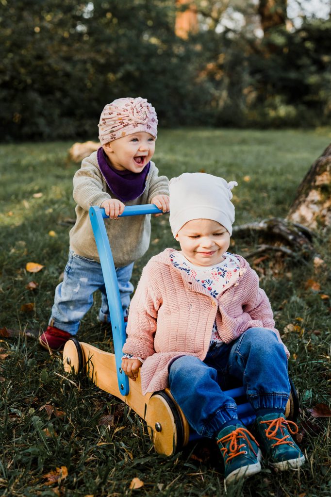 2 Kinder spielen auf der Wiese.